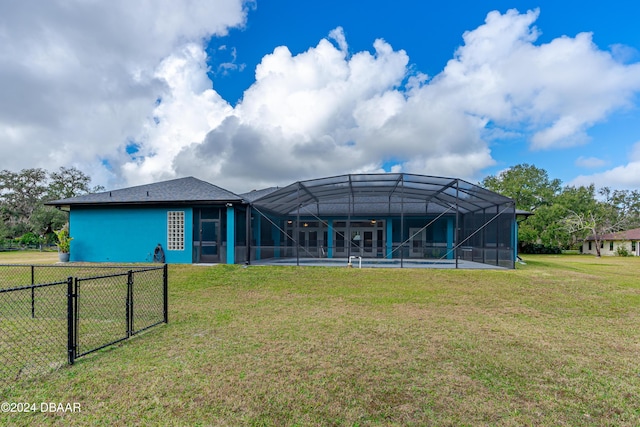 rear view of property with a yard, glass enclosure, and a swimming pool