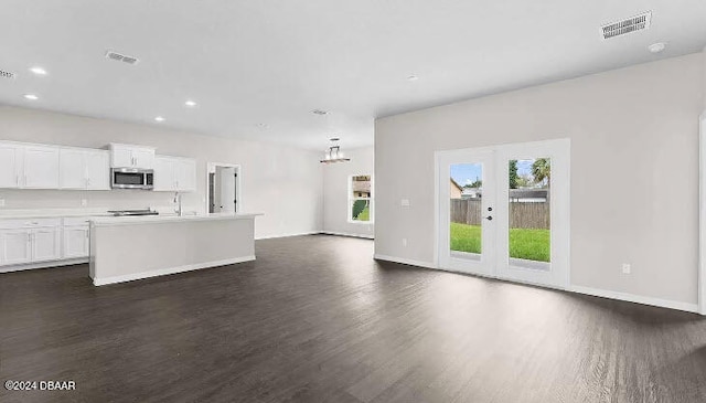 unfurnished living room featuring dark hardwood / wood-style floors, sink, and french doors