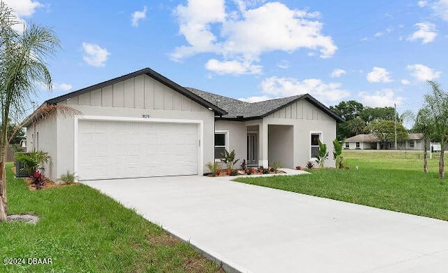 view of front of home featuring board and batten siding, a front yard, driveway, and an attached garage
