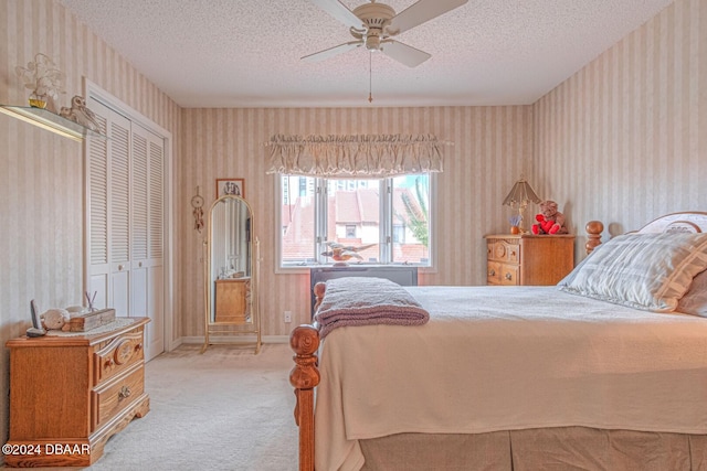 bedroom featuring a ceiling fan, a textured ceiling, carpet flooring, wallpapered walls, and baseboards