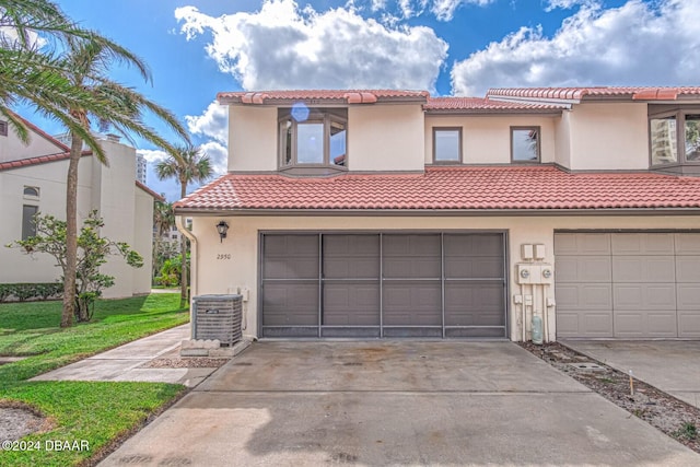 mediterranean / spanish house featuring cooling unit and a garage