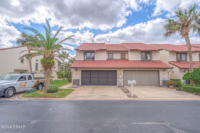 view of front of home featuring stucco siding, concrete driveway, central air condition unit, a garage, and a tiled roof