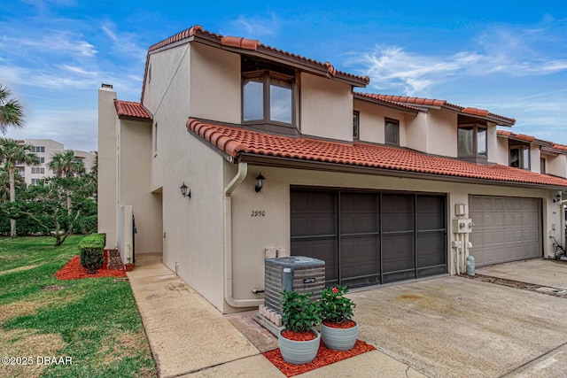 mediterranean / spanish house featuring cooling unit and a garage