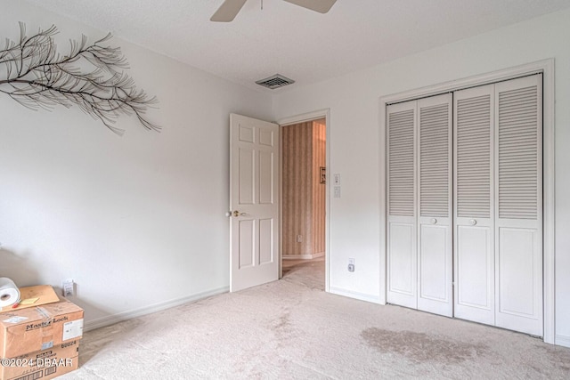 unfurnished bedroom featuring a ceiling fan, baseboards, visible vents, a closet, and carpet flooring