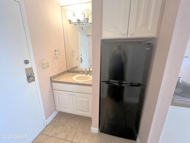 bathroom with vanity, tile patterned floors, baseboards, and a chandelier