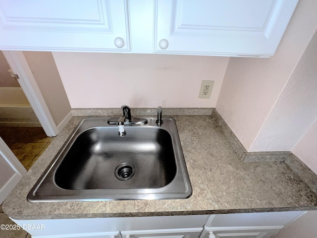 room details featuring white cabinetry and a sink