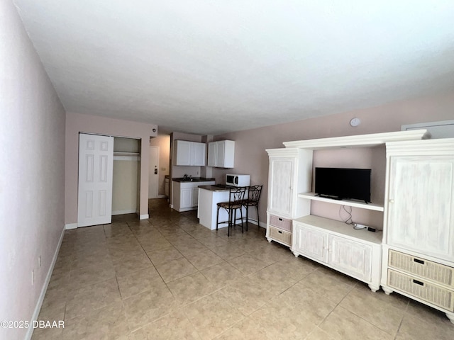 living area with light tile patterned floors and baseboards