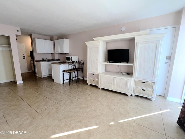 living room with light tile patterned floors and baseboards