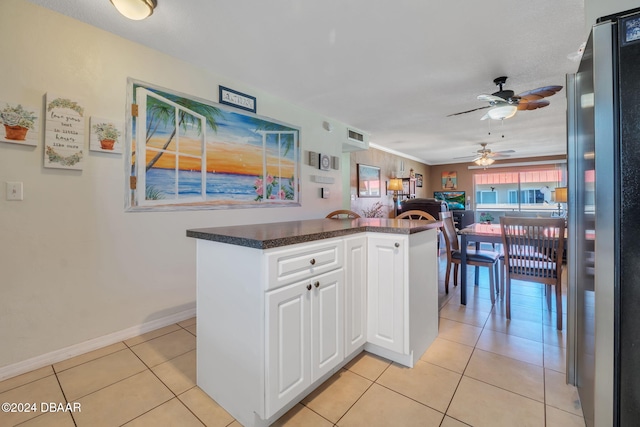2801 N Halifax Ave N Unit 238, Daytona Beach, FL 32118 - kitchen featuring freestanding refrigerator, a ceiling fan, dark countertops, white cabinetry, and light tile patterned flooring