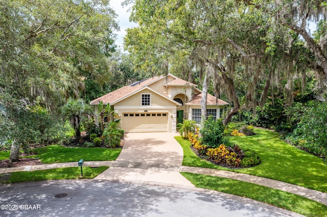 1324 Munster Cir, Ormond Beach, FL 32174 - view of front of home featuring stucco siding, concrete driveway, a front lawn, and an attached garage