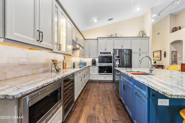 1324 Munster Cir, Ormond Beach, FL 32174 - kitchen featuring stainless steel appliances, beverage cooler, lofted ceiling, tasteful backsplash, and light stone countertops