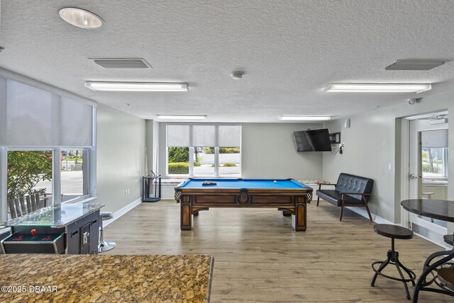 game room featuring a textured ceiling, billiards, baseboards, and wood finished floors