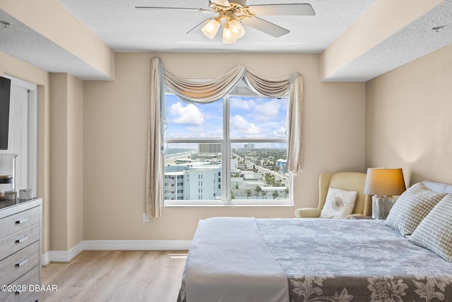 bedroom with wood finished floors, baseboards, and ceiling fan