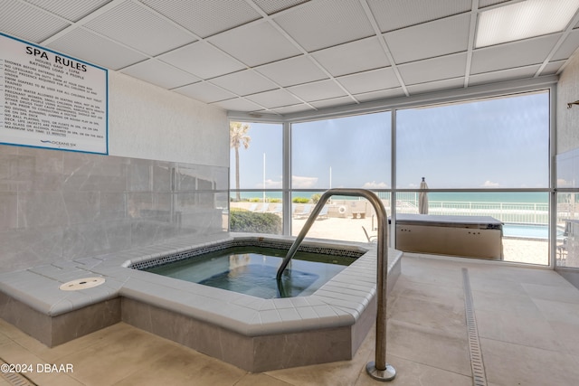 view of pool featuring a water view and an indoor in ground hot tub