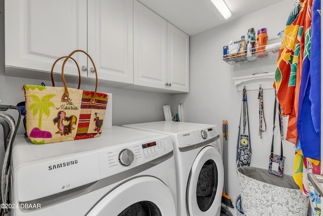 laundry area with washing machine and dryer and cabinets