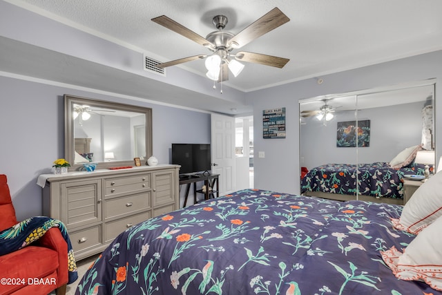 bedroom featuring ceiling fan, a textured ceiling, a closet, and crown molding