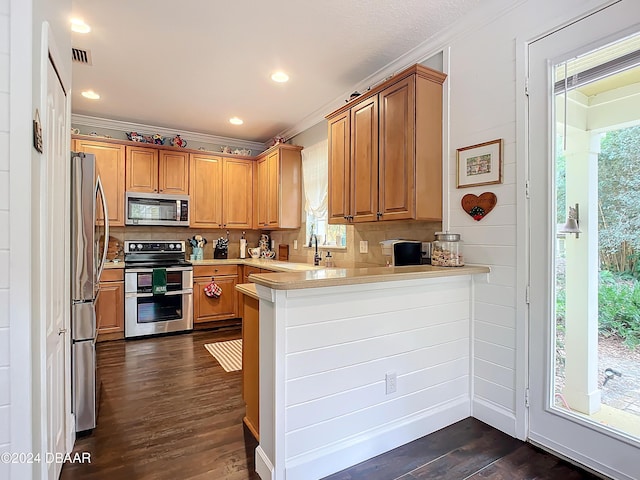 kitchen with kitchen peninsula, dark hardwood / wood-style flooring, backsplash, ornamental molding, and stainless steel appliances