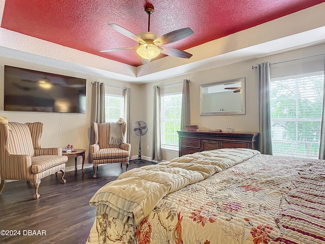 bedroom featuring ceiling fan, dark hardwood / wood-style flooring, and a textured ceiling