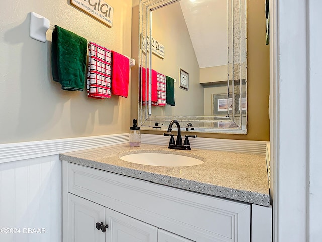 bathroom featuring vanity and lofted ceiling