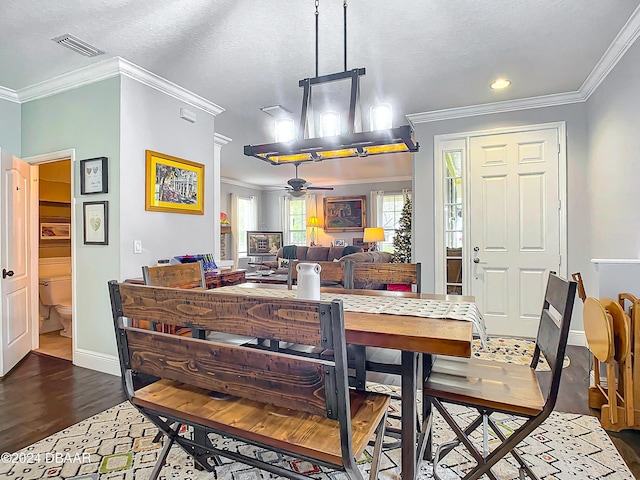 dining room featuring wood-type flooring, a textured ceiling, ceiling fan, and crown molding