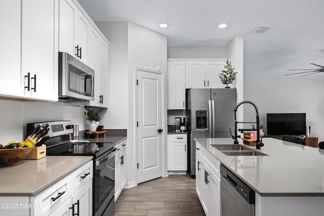2518 Hoptree Ln, Edgewater, FL 32141 - kitchen featuring white cabinets, stainless steel appliances, a sink, visible vents, and wood finished floors