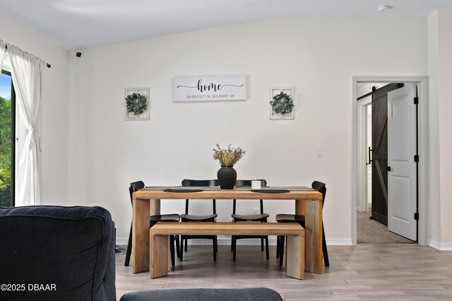 2518 Hoptree Ln, Edgewater, FL 32141 - dining area featuring a barn door, light wood-type flooring, and baseboards