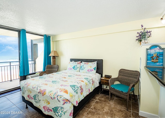 bedroom with a textured ceiling and access to outside