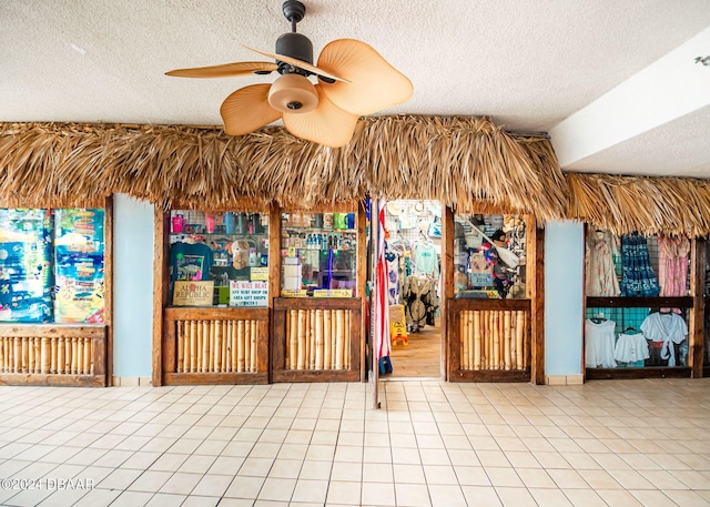 miscellaneous room with tile patterned flooring, a textured ceiling, and ceiling fan