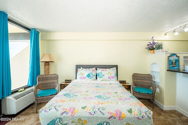 tiled bedroom featuring multiple windows, track lighting, and a textured ceiling