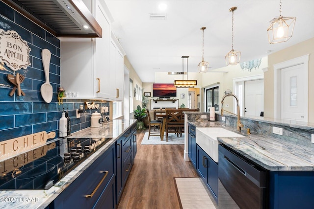 4 Oakview Ct, Palm Coast, FL 32137 - kitchen with blue cabinetry, stainless steel dishwasher, a sink, black electric cooktop, and tasteful backsplash