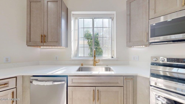 kitchen featuring plenty of natural light, stainless steel appliances, light countertops, and a sink