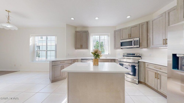 kitchen featuring light countertops, light tile patterned floors, recessed lighting, appliances with stainless steel finishes, and a peninsula