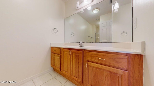 bathroom with tile patterned flooring, vanity, a shower, and baseboards