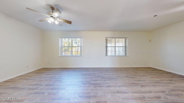 unfurnished room with a healthy amount of sunlight, baseboards, ceiling fan, and wood finished floors