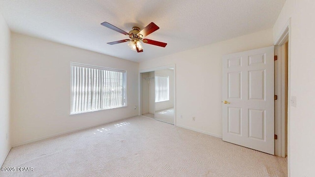 unfurnished bedroom with a closet, carpet floors, baseboards, and a ceiling fan