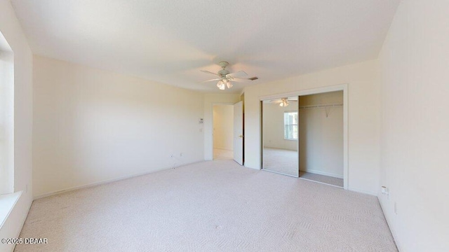 unfurnished bedroom with a closet, light carpet, and ceiling fan