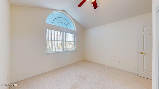 carpeted spare room featuring baseboards, a ceiling fan, and lofted ceiling