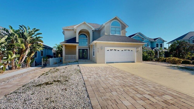 traditional-style home with stucco siding, an attached garage, concrete driveway, and fence