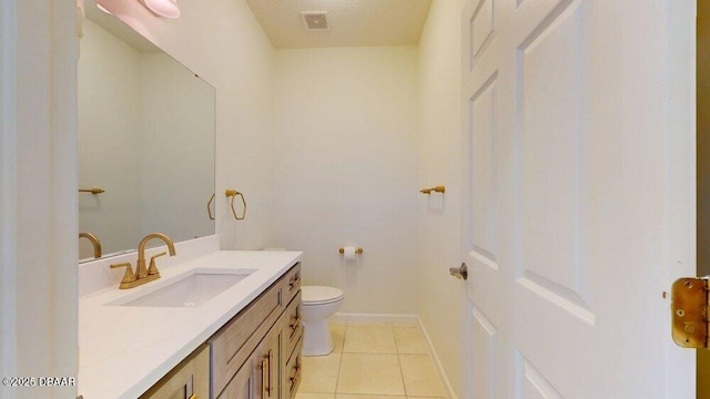 bathroom with tile patterned flooring, visible vents, baseboards, toilet, and vanity