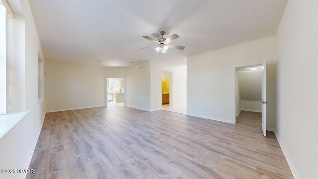 empty room featuring light wood-style flooring, baseboards, and ceiling fan