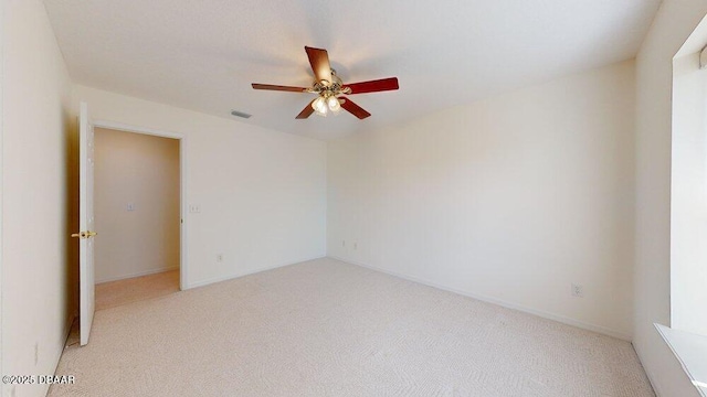 empty room with light carpet, visible vents, and ceiling fan