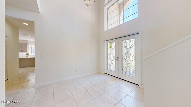 foyer entrance with light tile patterned floors, baseboards, a high ceiling, recessed lighting, and french doors