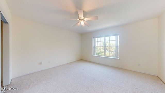 unfurnished room with light carpet, baseboards, and ceiling fan