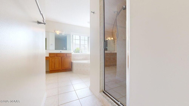 bathroom with tile patterned floors, vanity, a bath, and a shower stall