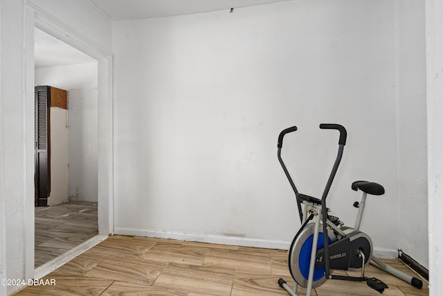 workout room with light hardwood / wood-style flooring