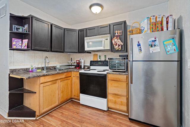 kitchen with backsplash, white appliances, sink, and light hardwood / wood-style floors