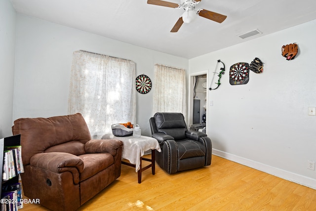 living area with hardwood / wood-style floors and ceiling fan