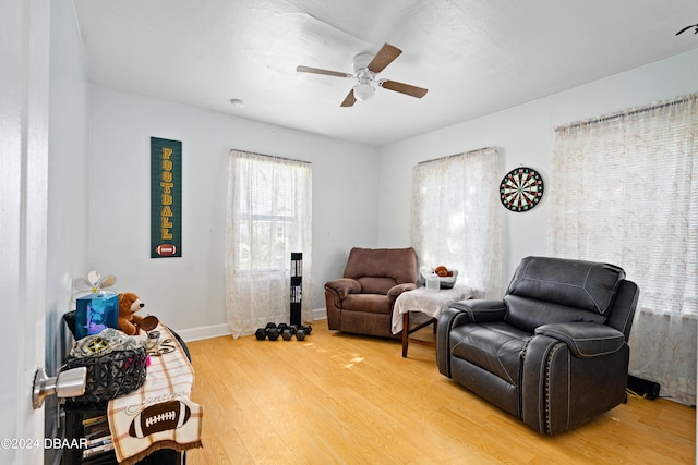 living area featuring wood-type flooring and ceiling fan