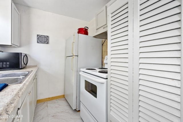 kitchen featuring white electric range, white cabinetry, and sink