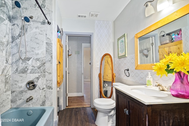 full bathroom featuring toilet, tiled shower / bath combo, vanity, and hardwood / wood-style floors